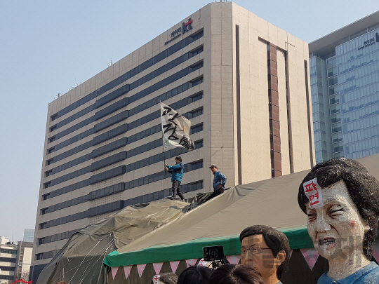 이해성 광장극장 블랙텐트이 천막해체식에서 깃발을 흔들고 있다.