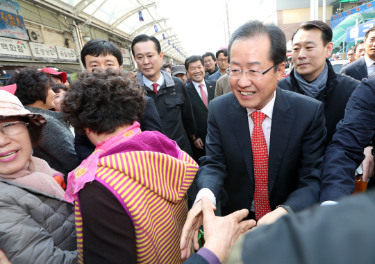 자유한국당 홍준표 경삼남도지사가 18일 오후 대구 서문시장에서 대통령선거 출마를 선언한 뒤 지지자들과 악수하고 있다. /대구=연합뉴스