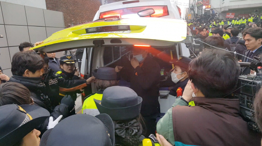 박근혜 전 대통령의 지지자가 탄핵을 반대하며 울부짖다 쓰러져 구급차로 이송되고 있다./정순구기자.