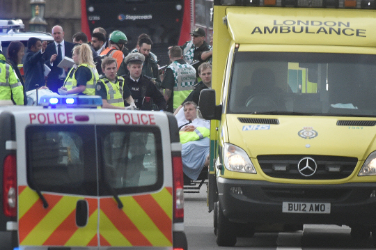 22일(현지시간) 영국 런던 웨스트민스터 의사당 인근에서 테러가 발생한 후 경찰과 구급대원들이 부상자들을 병원으로 옮기고 있다./런던=신화연합뉴스