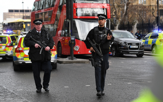 22일(현지시간) 영국 런던 국회의사당 인근에서 무장한 경찰이 테러가 발생한 도로로의 접근을 제지하고 있다./런던=EPA연합뉴스