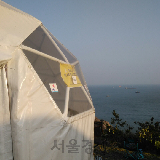 23일 오후 전남 진도군 동거차도 보퉁굴산 정상에 텐트를 친 세월호 유가족들이 멀리 희미하게 보이는 세월호 인양작업을 지켜보고 있다./동거차도=최성욱기자