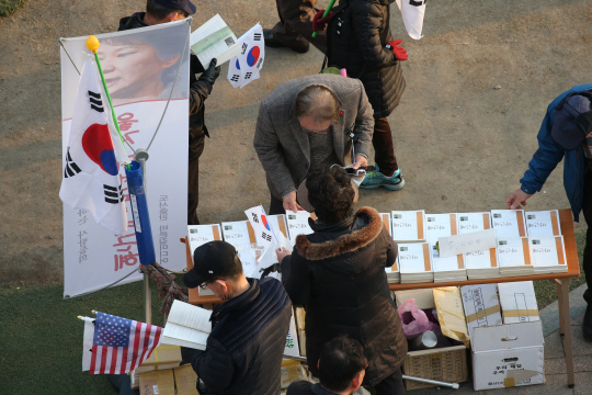 지난 11일 서울 시청 앞 서울광장에서 열린 탄핵반대집회에서 박사모 회원들이 자신들이 만드는 새누리당 입당원서를 받고 있다./연합뉴스