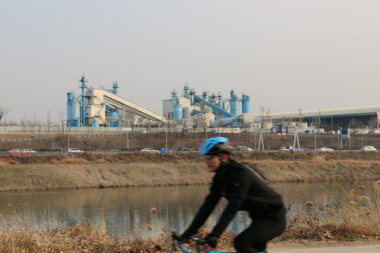 중랑천 건너편 레미콘공장인 삼표산업 성수공장을 배경으로 자전거가 지나고 있다.