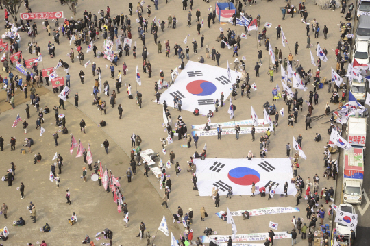 25일 오후 서울 시청 광장에서 열린 탄핵 국민저항본부 집회에서 참석자들이 대형 태극기를 들고 집회를 열고 있다. / 연합뉴스