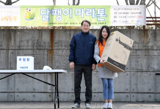 흐흐 역시 경품이 짱이야 … 26일 서울숲 야외무대에서 진행된 ‘서울경제와 성동구가 함께하는 서울숲길 달팽이 마라톤’의 경품추첨 행사에서 1위인 청호나이스 공기청정기의 당첨자(오른쪽)가 이종환 서울경제신문 대표이사 부회장과 기념촬영하고 있다.  /권욱기자