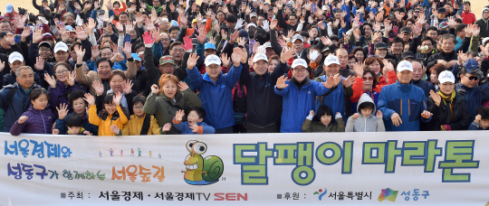 서울경제신문이 주최하고 서울시와 성동구가 후원한 ‘서울경제와 성동구가 함께하는 서울숲길 달팽이 마라톤’ 행사가 26일 서울 성동구 사근동 살곶이체육공원에서 300여명의 시민들이 참가한 가운데 성황리에 열렸다. 참가자들은 서울숲 야외무대까지 4.5㎞를 걸었다. 출발에 앞서 홍익표(앞줄 왼쪽 여섯번째) 더불어민주당 의원, 이종환(〃〃 일곱번째) 서울경제신문 대표이사 부회장, 정원오(〃〃여덟번째) 성동구청장 등이 시민들과 함께 파이팅을 외치고 있다.  /이호재기자