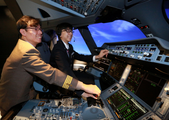 항공 영재로 알려진 이택현(오른쪽)군과 황남식 아시아나항공 기장이 27일 서울 강서구 아시아나타운 운항훈련동에서 진행된 ‘A350 시뮬레이터 체험 프로그램’에서 시뮬레이터 조작법 교육 등을 받고 있다./사진제공=아시아나항공