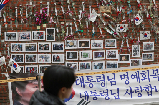 25일 오전 서울 삼성동 박근혜 전 대통령 자택 담벼락에 박 전 대통령의 사진 등이 붙어있다. / 연합뉴스