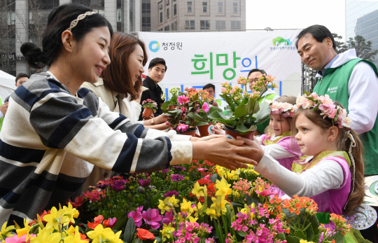 봄의 요정이 된 어린이들이 28일 오전 서울 청계광장에서 열린 '2017 희망의 나무나누기 행사'에서 꽃화분을 나눠주고 있다. 이번 행사를 주최한 대상(주) 청정원은 식목일을 앞두고 미세먼지 걱정 없는 청정지구를 만들자는 의미에서 금강소나무 포함 총 11종 1만 그루의 묘목을 시민들에게 나누어 준다고 전했다./권욱기자