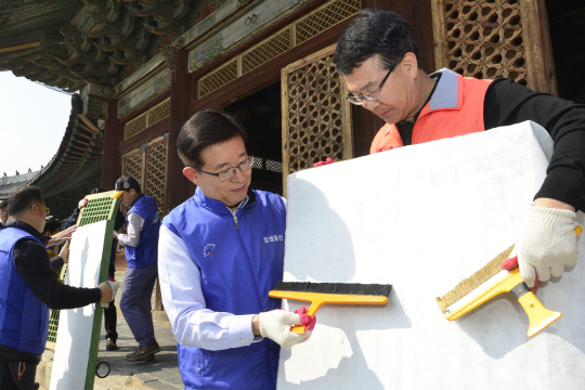 김봉영(왼쪽) 삼성물산 리조트부문 사장과 박정상 창경궁 관리소장이 국보 226호로 지정된 창경궁 명정전의 오래된 창호지를 교체하고 있다. 삼성물산 리조트부문은 29일 서울 종로구 창경궁에서 ‘문화재 지킴이’ 봉사활동을 펼쳤다. /사진제공=삼성물산