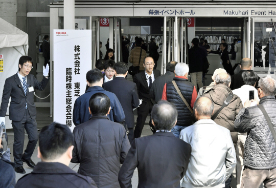 도시바의 임시주주총회장인 일본 지바현 지바시 마쿠하리메세의 강당으로 30일 주주들이 몰려들어가고 있다. 이날 주총에서는 반도체 메모리 부문 분사안이 가결됐다.    /지바=교도연합뉴스