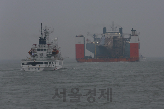 세월호를 실은 반잠수식 선반이 31일 오전 7시 사고해역에서 목포 신항을 향해 출발하고 있다. 세월호와 함께 해경 경비함이 목포 신항까지 안전 호송과 경비 안전을 위해 함께 이동하고 있다./목포=사진공동취재단