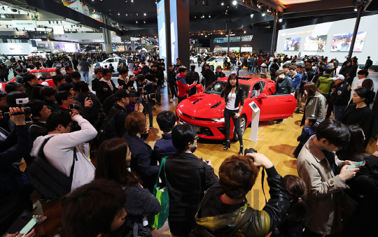 서울모터쇼가 열리는 일산 킨텍스 한국GM 부스에서 관람객들이 모델과 카마로를 촬영하고 있다./사진제공=한국GM