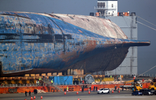 세월호가 실린 반잠수식 선박에서 작업자들이 육상 거치를 위한 펄 제거 작업을 하고 있다. /연합뉴스