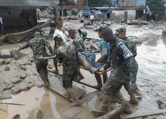 콜롬비아 남서부 푸투마요주(州) 모코아에서 지난달 31일(현지시간) 밤 폭우로 강이 범람하고 산사태가 나면서 지금까지 최소 206명이 사망하고 220명이 실종됐다. 사진은 1일 모코아에서 군인들이 산사태 희생자의 시신을 옮기는 모습. /AFP연합뉴스