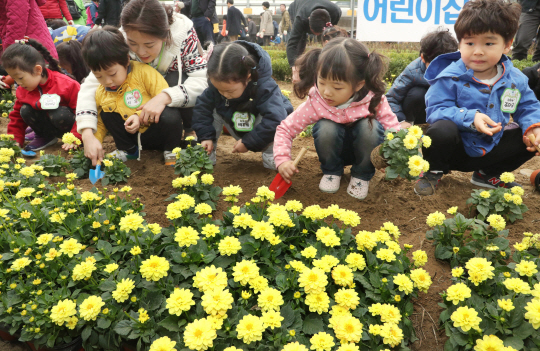 5일 서울 중랑구 묵동천 자연학습장에서 열린 식목일 행사에 참가한 어린이들이 꽃밭에 꽃을 심고 있다.  /연합뉴스