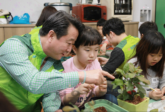 현장경영에 나선 이웅열 코오롱 회장이 5일 코오롱제약 생산공장이 있는 대전에서 임직원의 정기봉사처인 세계중앙지역아동센터 아이들과 함께 ‘내일의 희망’이라는 꽃말의 산호수 화분을 만들고 있다. /사진제공=코오롱그룹