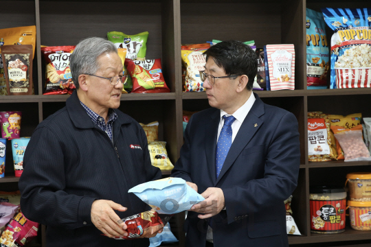 임채운(오른쪽) 중진공 이사장이 6일 경기도 성남에 위치한 팝콘 제조업체 제이앤이의 김재호 대표를 만나 수출 애로 사항을 듣고 있다./ 사진제공=중진공