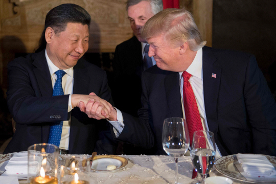 도널드 트럼프(오른쪽) 미국 대통령과 시진핑 중국 국가주석이 6일(현지시간) 미 플로리다주 팜비치의 마라라고 리조트에서 열린 만찬에서 환하게 웃으며 악수하고 있다.  /팜비치=AFP연합뉴스