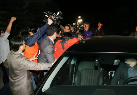 박동식 경남도의회 의장이 자유한국당 대선 후보인 홍준표 지사가 공직자 사퇴시한인 9일 자정 3분 전에 사임통지서를 보내왔다고 발표하고 승용차로 자리를 떠나려 하자 더불어민주당과 정의당 경남도당 당직자와 시민단체 등이 구체적 사퇴 경위를 밝힐 것을 촉구하며 항의하고 있다./연합뉴스