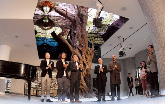 도중섭(왼쪽 세 번째)워커힐 총괄사장이 13일 ‘비스타 워커힐 서울’ 리뉴얼 오픈 기념식에서 참석자들과 박수를 치고 있다. 뒤편에 위치한 나무는 800년 된 시칠리산 올리브나무다. 세계적인 플랜트 헌터 니시하타 세이준의 국내 첫 작품이다./이호재기자.