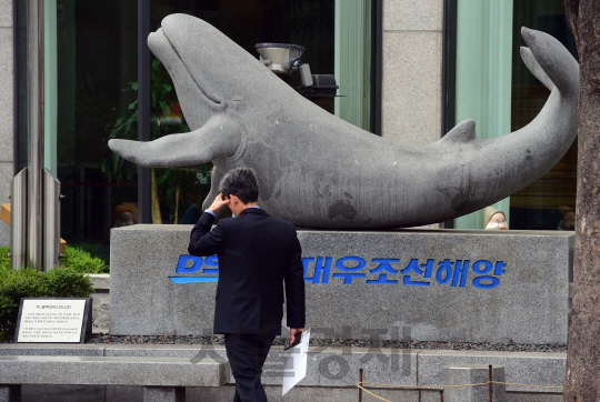 대우조선해양의 채무재조정안을 놓고 산업은행과 국민연금이 막판 협상을 벌인 14일 서울 중구 다동 대우조선해양 본사 표지석 앞을 직원이 지나가고 있다.        /이호재기자