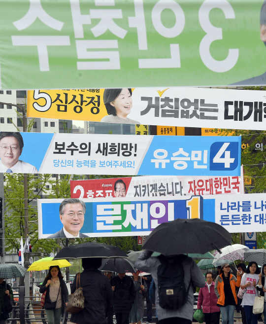 전국에 봄비가 촉촉히 내리고 있는 17일 오전 서울 서대문구 거리에서 시민들이 제19대 대선에 출마한 후보들의 현수막이 걸려 있는 횡단보도를 건너고 있다./이호재기자.s020792@sedaily.com