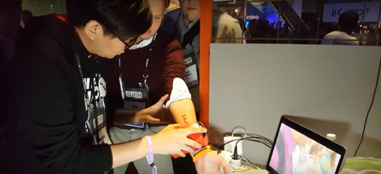 지난해 핀란드 헬싱키에서 열린 스타트업 컨퍼런스 ‘슬러시’에서 한 관람객이 스케치온의 프링커를 이용해 팔에 문신을 새기고 있다./사진제공=스케치온