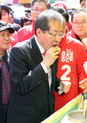 홍준표 자유한국당 대선후보가 18일 오전 울산 남창시장에서 상인이 준 국화빵을 먹고 있다.    /연합뉴스