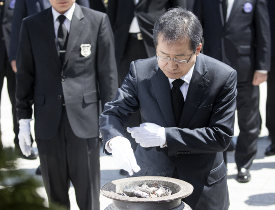 홍준표 자유한국당 대선후보가 19일 오전 서울 강북구 국립 4.19 민주묘지를 찾아 4.19 학생혁명기념탑에 분향하고 있다. 이날 홍 후보는 ‘이 땅에 민중주의가 아닌 민주주의를!’이라는 메시지를 방명록에 남겼다./연합뉴스