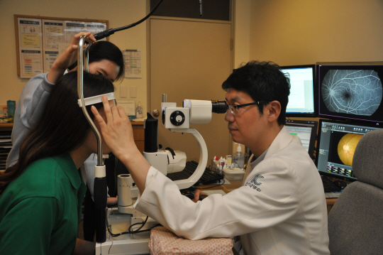 이동원(오른쪽) 김안과병원 망막센터장이 망막질환이 있는지 세극등현미경 검사를 하고 있다. /사진제공=김안과병원