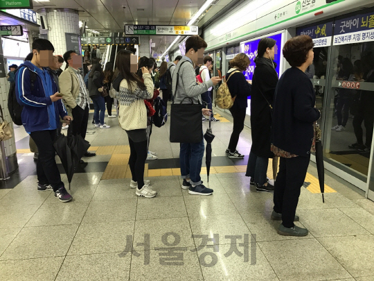 비가 내린 지난 18일 서울 구로구 신도림역 2호선 플랫폼에서 일부 시민들이 우산덮개를 씌우지 않은 채 지하철을 기다리고 있다. /이두형기자