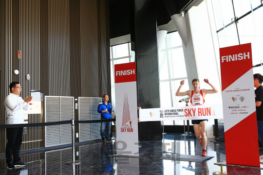 롯데물산이 주최한 ‘롯데월드타워 국제 수직 마라톤 대회 스카이런’ 엘리트 부문 남자 1등인 호주 출신의 마크 본 선수가 15분 44초 51의 기록으로 피니쉬라인을 들어서고 있다./사진제공=롯데물산