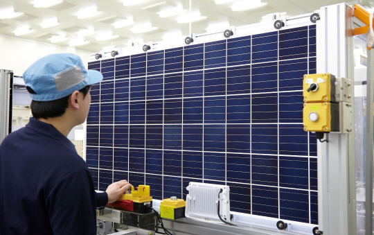 충청북도 음성에 있는 한화큐셀 태양광 셀 공장에서 한 직원이 태양광 모듈 상태를 점검하고 있다.
