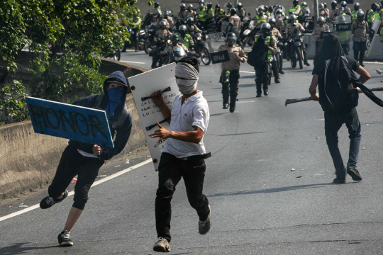 베네수엘라 수도 카라카스에서 반정부시위 참가자들이 경찰을 피해 달아나고 있다. /카라카스=EPA연합뉴스