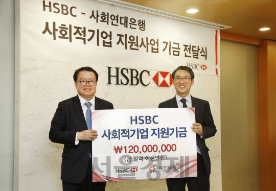 정은영(오른쪽) HSBC코리아 행장과 김용덕 사회연대은행 대표가 26일 서울 HSBC코리아 빌딩에서 사회적기업 지원기금을 전달하고 기념촬영을 하고 있다./사진제공=HSBC코리아