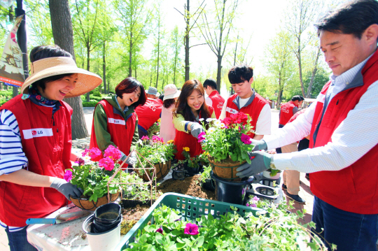 LG전자 임직원들이 지난 27일 서울 광진구 어린이대공원에서 환경보호 활동을 하고 있다.  LG전자는 5월말 까지 총 40개 부서 2,000여 명이 릴레이 자원봉사에 참가한다./사진제공=LG전자