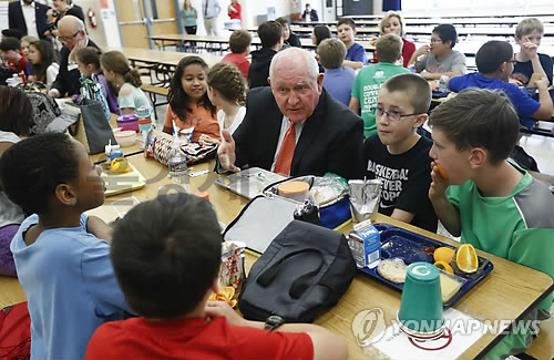 버지니아주 리스버그의 한 초등학교를 방문한 퍼듀 장관이 카페테리아에서 학생들과 함께 식사를 하며 대화를 나누는 모습/연합뉴스