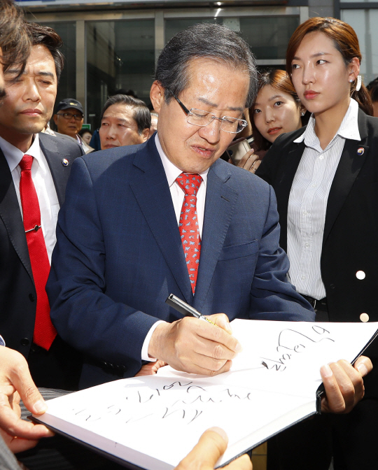 홍준표 자유한국당 대선후보가 3일 서울 마포의 홍익지구대 방문을 마친 뒤 한 시민에게 사인을 해주고 있다. /연합뉴스