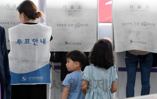 제19대 대통령선거 사전투표가 시작된 4일 오전 서울역에 마련된 남영동 사전투표소에서 부모님과 함께 온 어린이들이 투표장면을 지켜보고 있다./권욱기자ukkwon@sedaily.com