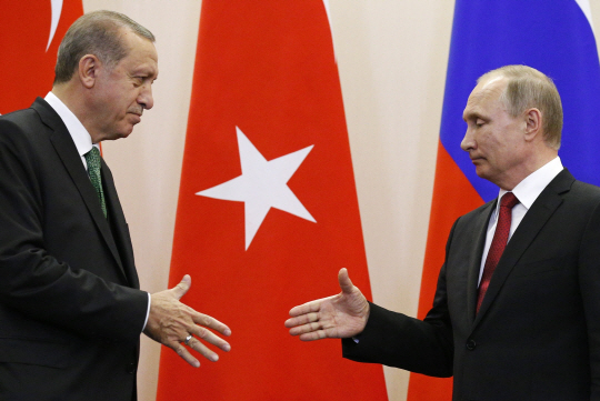블라디미르 푸틴(오른쪽) 러시아 대통령과 레제프 타이이프 에르도안 터키 대통령이 3일 러시아 소치에서 기자회견을 마친 뒤 악수하기 위해 손을 내밀고 있다. 소치=AP연합뉴스