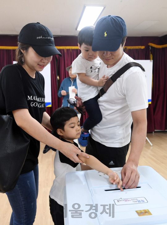 어린이날인 5일 아이들과 함께 서울 광진구 구의제2동 주민센터에 마련된 사전투표소를 찾은 젊은 부부가 소중한 한 표를 행사하고 있다.  /권욱기자