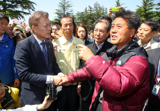 문재인(왼쪽) 더불어민주당 후보가 7일 오전 강릉 성산초등학교에 산불로 긴급 대피해 있는 이재민들을 위로하고 있다. /연합뉴스