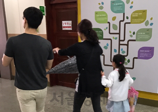 제19대 대통령선거일인 9일 서울 양천구 목운초등학교에 마련된 투표소에 아이의 손을 잡은 부모가 들어서고 있다. /이두형기자