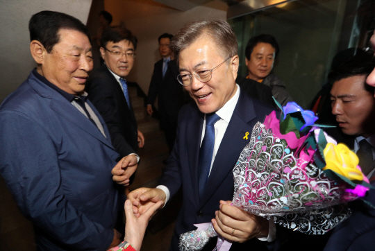 더불어민주당 문재인 후보가 9일 오후 국회를 찾은 뒤 다시 서울 서대문구 홍은동 자택으로 돌아오며 주민들과 지지자들에게 축하 꽃다발을 받고 있다.