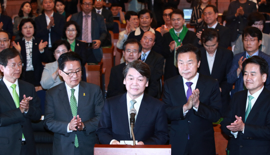 안철수 국민의당 대선후보가 9일 밤 서울 여의도 국회 헌정기념관에 마련된 국민의당 선대위 개표상황실을 찾아 입장을 밝히기 앞서 박지원 중앙상임선대위원장 등 선대위 관계자들로부터 박수를 받고 있다. /연합뉴스