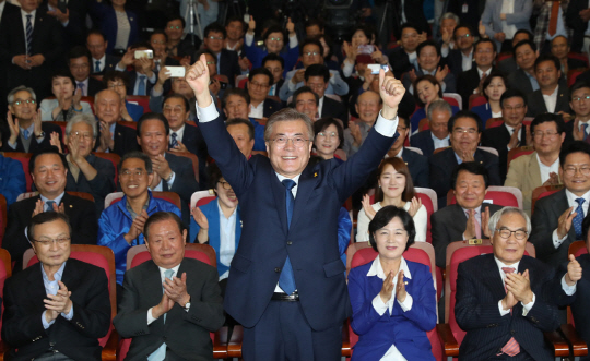 문재인 대통령이 9일 출구조사에서 다른 후보들을 큰 격차로 따돌린 결과가 나온 직후 서울 여의도 국회의원회관 대회의실 마련된 개표상황실로 들어서 두 손을 번쩍 들어 인사하고 있다./연합뉴스.