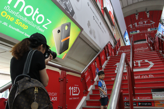 태국 방콕 BTS 시암역에서 한 관광객이 11번가 래핑광고를 배경으로 기념촬영을 하고 있다./이지윤기자