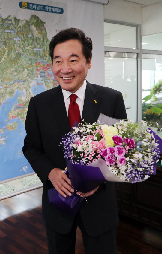 이낙연 국무총리 후보자가 11일 전남 무안의 전남도청에서 직원으로부터 축하 꽃다발을 받고 환하게 웃고 있다. /연합뉴스